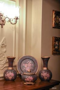 科爾察的住宿－Vila Sonnet，两个花瓶坐在一张桌子上,盘子