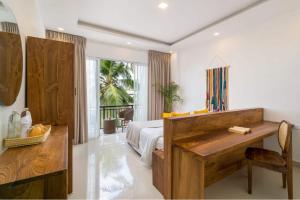 a bedroom with a bed and a desk in it at Outpost Weligama Beachfront in Weligama