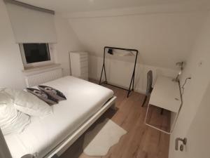 - une chambre blanche avec un lit et un miroir dans l'établissement Precioso apartamento, fantásticas vistas, à Augustusburg