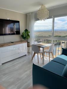 a living room with a dining table and a television at Four Seasons in Empuriabrava