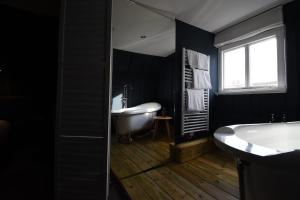 a black bathroom with a tub and a sink at Whitehouse Rye in Rye +24 photos