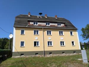 ein großes gelbes Gebäude mit schwarzem Dach in der Unterkunft Precioso apartamento, fantásticas vistas in Augustusburg