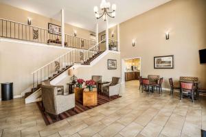 a living room with a staircase and tables and chairs at Quality Inn Arkadelphia - University Area in Arkadelphia