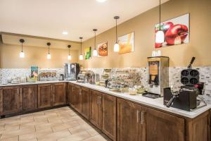 a kitchen with wooden cabinets and a counter at Quality Inn Arkadelphia - University Area in Arkadelphia