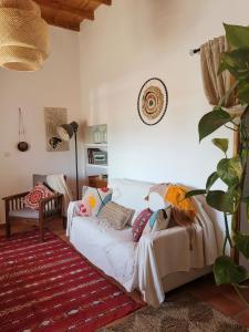 ein Wohnzimmer mit einer weißen Couch und einem Teppich in der Unterkunft Cortijo La Ciclona in Fernán Pérez