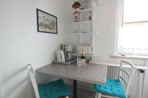 eine Küche mit einem Tisch mit 2 Stühlen und einer Theke in der Unterkunft Moin Moin in Hörnum