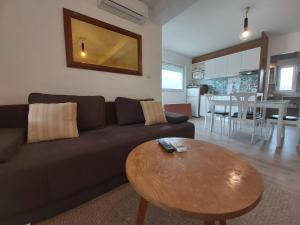 ein Wohnzimmer mit einem braunen Sofa und einem Tisch in der Unterkunft Sobe Dragić in Zadar