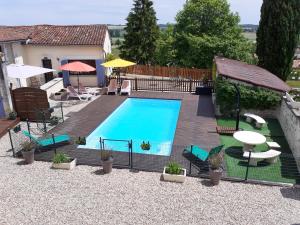 una piscina en un patio trasero con mesa y sillas en Maison Belle Vue en Cherval