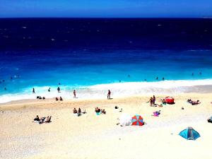 a group of people on a beach with the ocean at Rose Hotel B&B in Patara