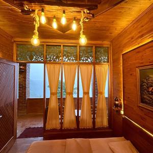 a bedroom with a large window with curtains at Bagas Luxury Camp in Kejajar