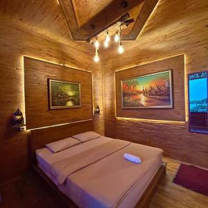 a bedroom with a bed in a wooden room at Bagas Luxury Camp in Kejajar