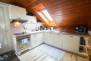 cocina con armarios blancos y techo de madera en Holiday Home Linda en Liptovský Mikuláš