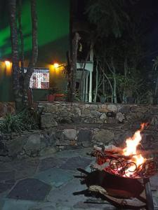 a fire pit in a yard at night at CASA DA MATA descanso e sossego na natureza in Ibicoara