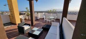 ein Balkon mit Tisch und Stühlen auf einem Dach in der Unterkunft Homes of Spain, Atico Lomas del Mar V con vistas al mar y solárium grande, WIFI in Playas de Vera