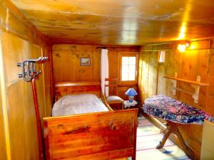 a small bedroom with a bed in a wooden cabin at Haus Nicca in Splügen