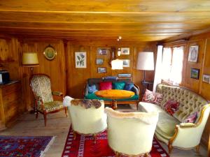 a living room with a couch and chairs and a table at Haus Nicca in Splügen