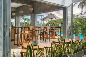 a patio with tables and chairs and a pool at Outpost Weligama Beachfront in Weligama