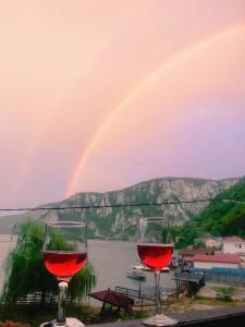 zwei Gläser Rotwein mit Regenbogen im Hintergrund in der Unterkunft La Cico 2 in Dubova
