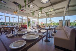uma sala de jantar com mesas, cadeiras e janelas em Sercotel AB Rivas em Rivas-Vaciamadrid