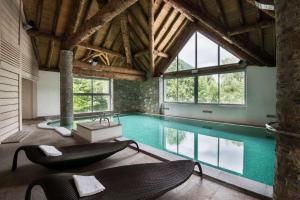 a large swimming pool with two chairs and a table at Appartement "L'Ostaloux" 6 personnes - Saint Lary Soulan in Vielle-Aure