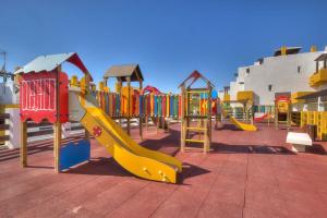 ein Spielplatz mit einer gelben Rutsche in einem Park in der Unterkunft Homes of Spain, Atico Lomas del Mar V con vistas al mar y solárium grande, WIFI in Playas de Vera
