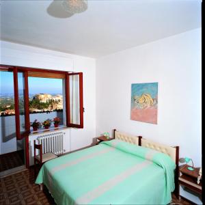 a bedroom with a bed and a large window at B&B Loreblick in Loreto Aprutino