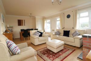 a living room with two couches and a table at Holiday Bungalow, short drive to 7 Beaches! in Saint Merryn