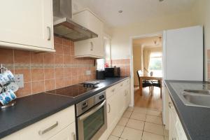 a kitchen with white cabinets and black counter tops at Holiday Bungalow, short drive to 7 Beaches! in Saint Merryn