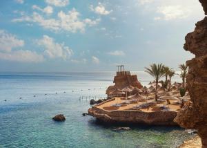 een strand met stoelen en parasols en de oceaan bij Dreams Beach Resort - Sharm El Sheikh in Sharm El Sheikh