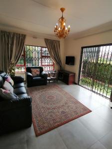 a living room with a couch and a rug at Garden and Park Leisure on Tugela in Benoni