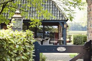 a wooden bench in front of a house at Landrop Bed & Breakfast in Hoogeloon