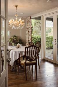 comedor con mesa, sillas y lámpara de araña en Landrop Bed & Breakfast, en Hoogeloon