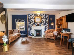 sala de estar con paredes azules y chimenea en The Cheese Room, en Moreton-in-Marsh