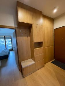 Pokój z drewnianymi szafkami i pokój z łóżkiem w obiekcie Summer - Neptun Park by OneApartments w Gdańsku