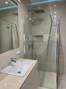 łazienka z umywalką i prysznicem w obiekcie Summer - Neptun Park by OneApartments w Gdańsku