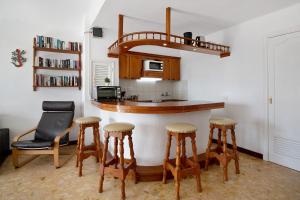cocina con barra con taburetes y microondas en Bungalow Flamingo en Playa Blanca
