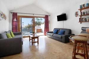 sala de estar con 2 sofás y TV en Bungalow Flamingo en Playa Blanca
