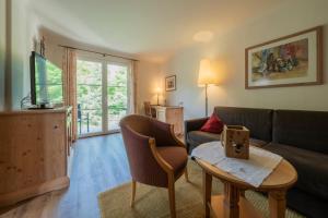 a living room with a couch and a table at Grüner Baum Naturparkhotel & Schwarzwald-Restaurant in Todtnau