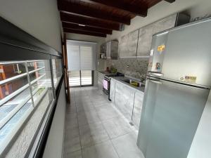 a kitchen with stainless steel appliances and a large refrigerator at Departamento para 4 personas in Tunuyán