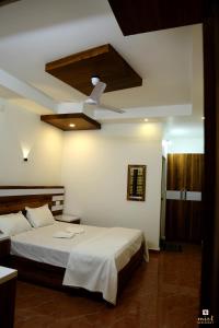 1 dormitorio con 1 cama y ventilador de techo en MIST RESIDENCY en Kattappana