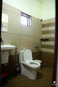 a bathroom with a toilet and a sink at MIST RESIDENCY in Kattappana
