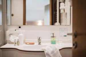 eine Badezimmertheke mit einem Waschbecken und einem Spiegel in der Unterkunft Grüner Baum Naturparkhotel & Schwarzwald-Restaurant in Todtnau