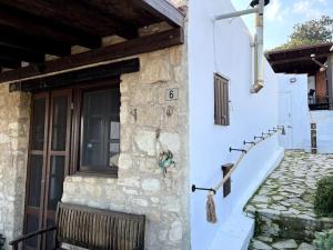 a stone house with a door and a bench on the side at 'I Folia' Village house with roof garden and terrace in Pissouri