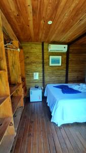 a bedroom with a bed in a wooden cabin at Pousada Barra Trip in Barra Grande