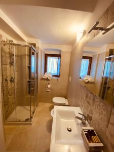 bagno con lavandino, doccia e servizi igienici di RELAIS SAN MARCO LUXURY GUEST HOUSE a Volturino