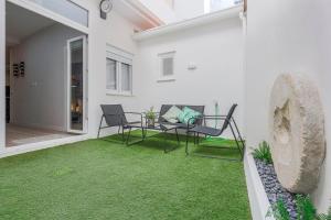 un patio con mesa, sillas y césped en Minimalismo de Vanguardia con altas calidades 1 BR en Sevilla