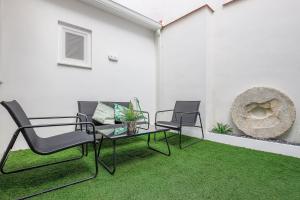 patio z 2 krzesłami, stołem i trawą w obiekcie Minimalismo de Vanguardia con altas calidades 1 BR w Sewilli