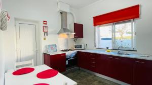 a kitchen with red cabinets and a sink and a window at Vital by Check-in Portugal in Albufeira