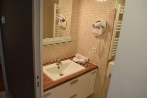 a bathroom with a sink and a mirror at Suite Appart'Hôtel La Loggia By M Spa in Deauville