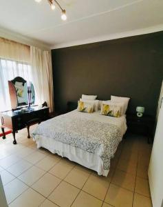 伯諾尼的住宿－Garden and Park Leisure on Tugela，一间卧室配有一张大床和一架钢琴